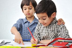 Two little boys doing school work